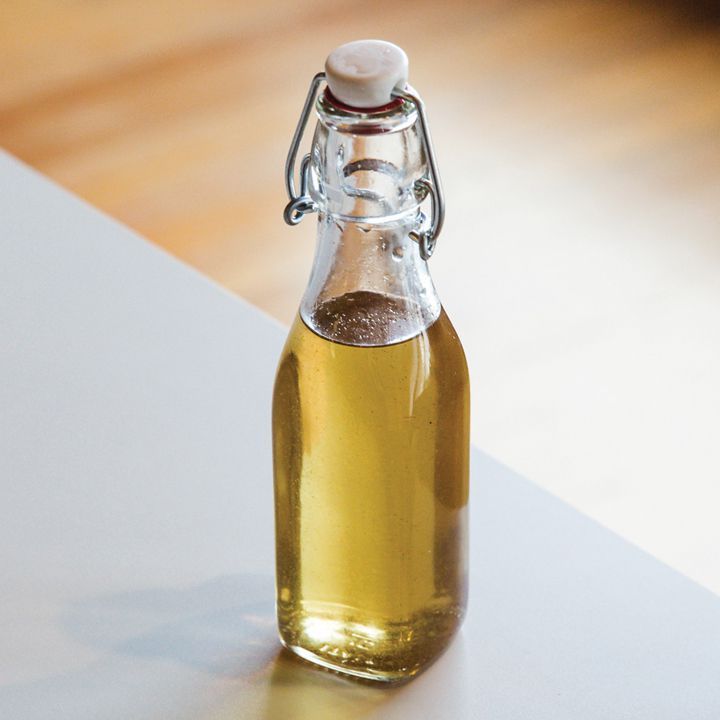 sirop de vanille simple dans une bouteille à couvercle pivotant assis sur un comptoir blanc