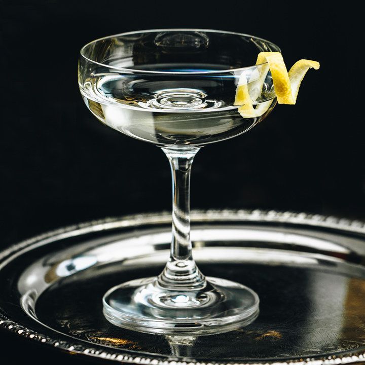 cocktail de vesper avec un zeste de citron, servi sur un plateau d'argent