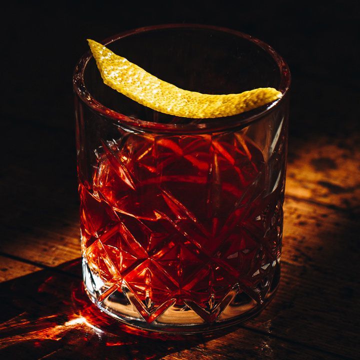 cocktail sazerac dans un verre taillé en cristal avec une garniture de zeste de citron
