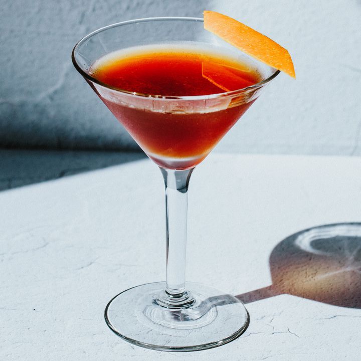 Sangue e sabbia in un bicchiere da cocktail con una guarnizione di scorza d'arancia